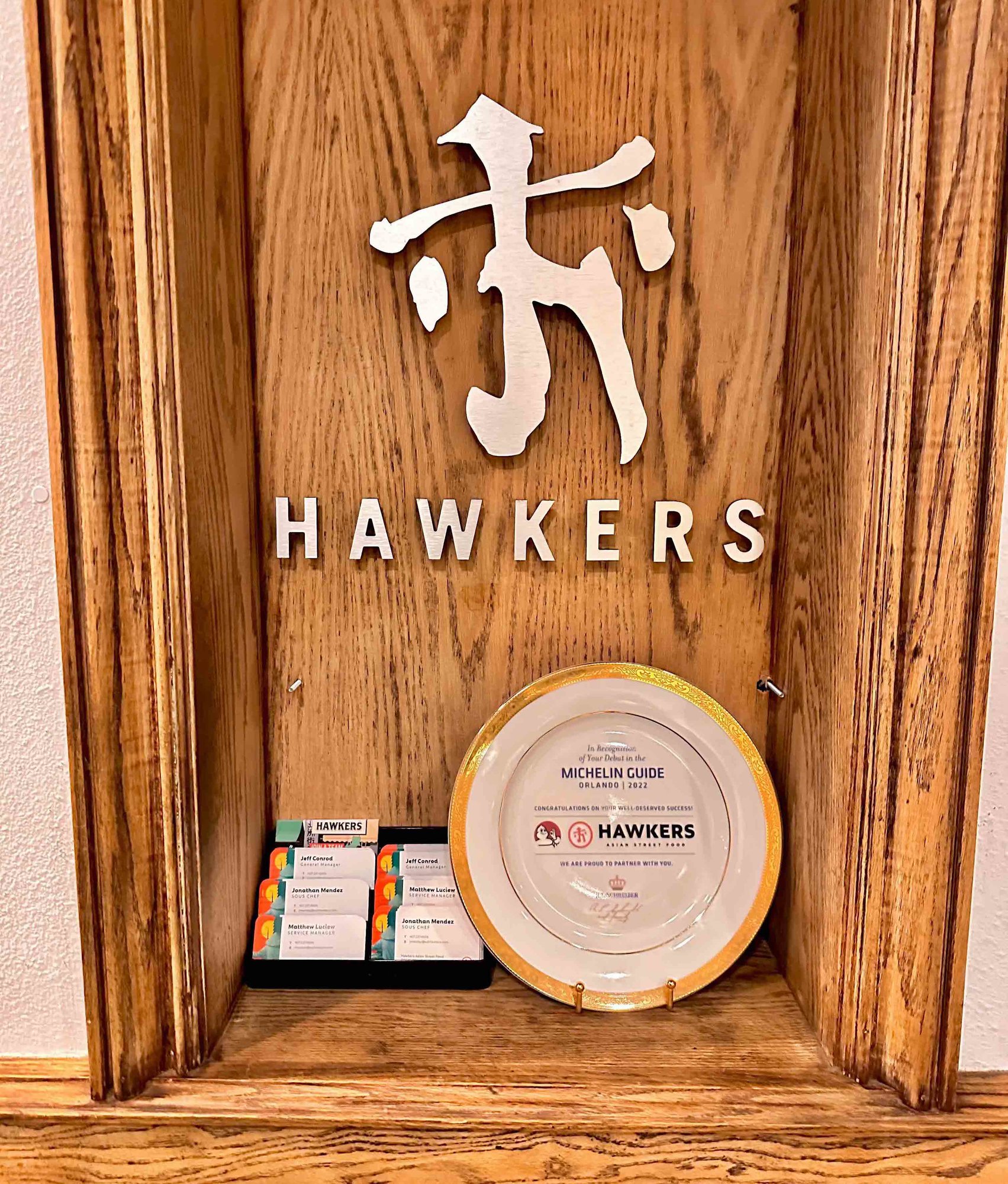 hawkers sign with wood background and michelin guide plate award